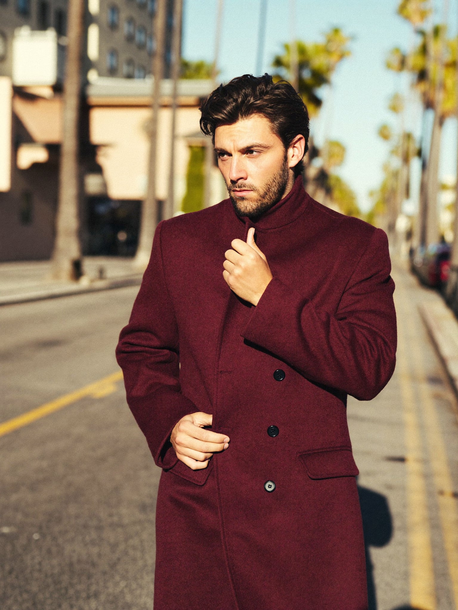 A man in a dark wool coat walking on an autumn London street