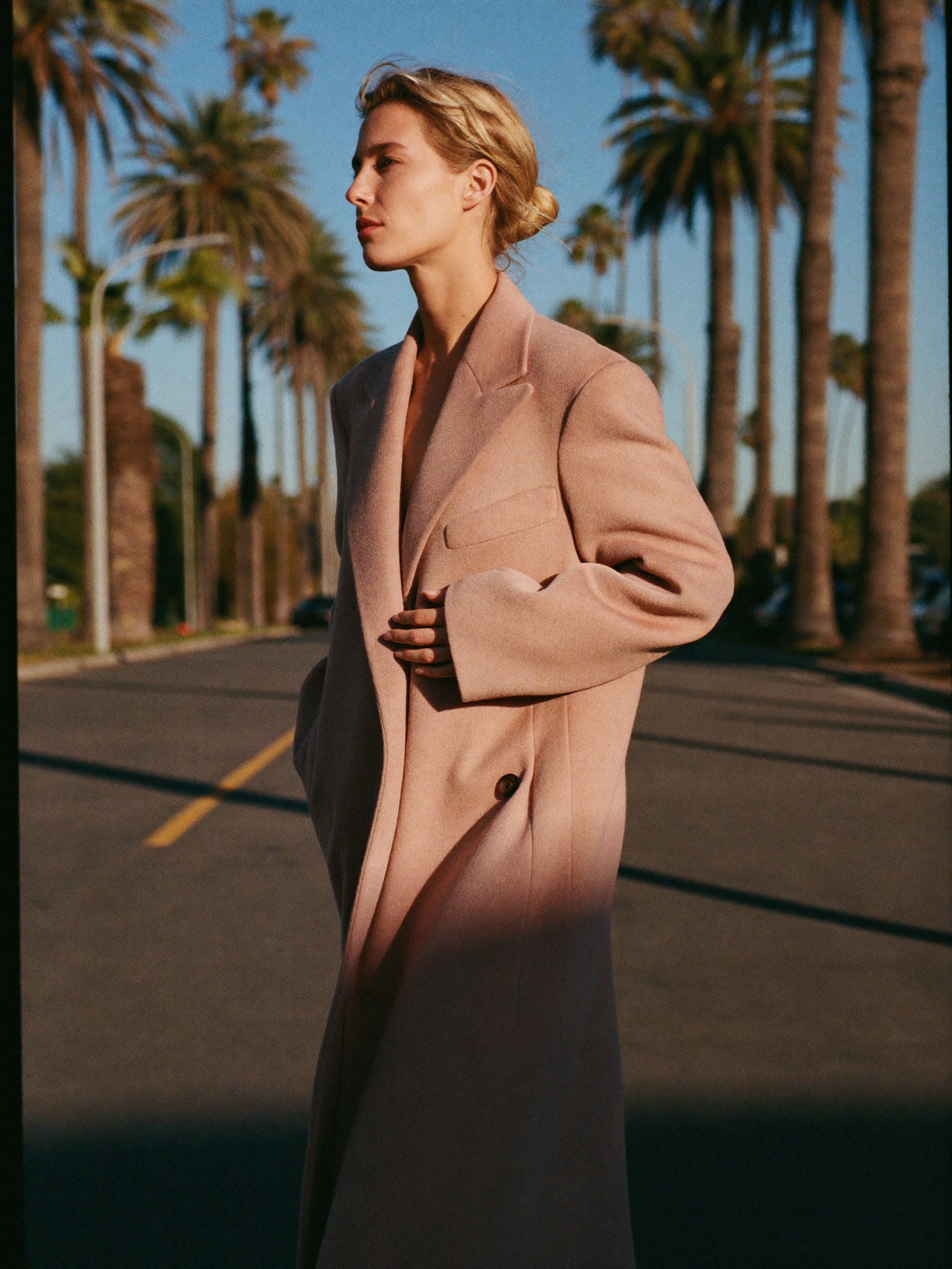 A woman in a camel coat walking on an autumn London street