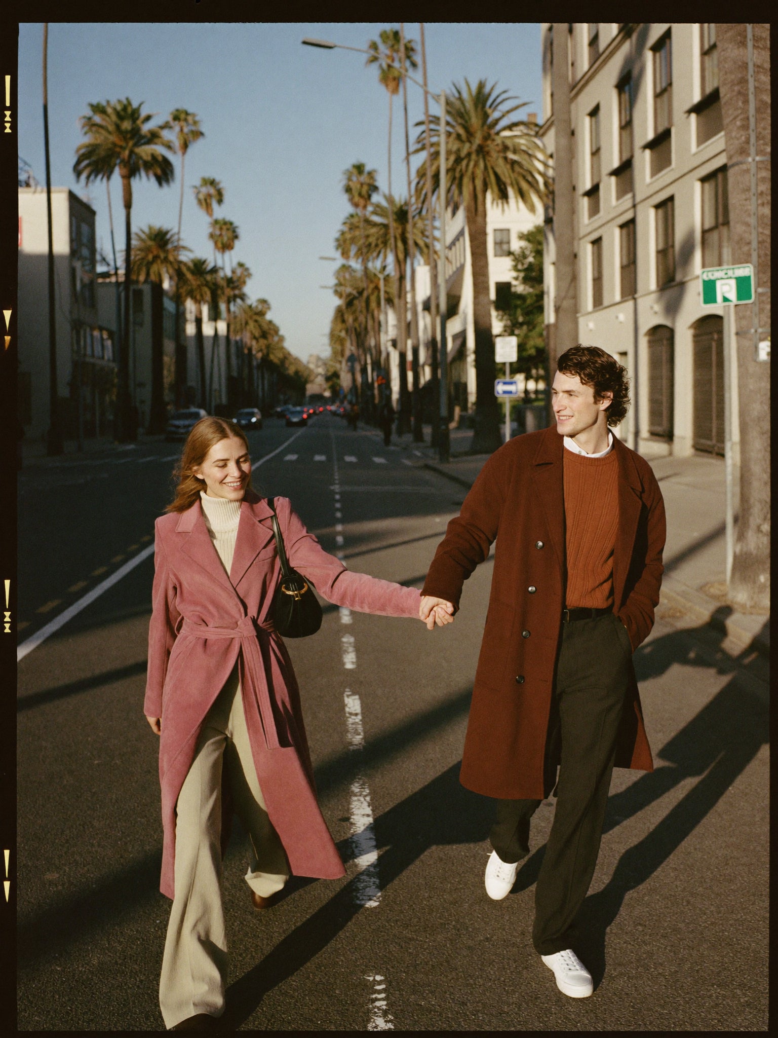 Two friends walking together on an autumn city street, styled in Rose Ellington outerwear and knitwear